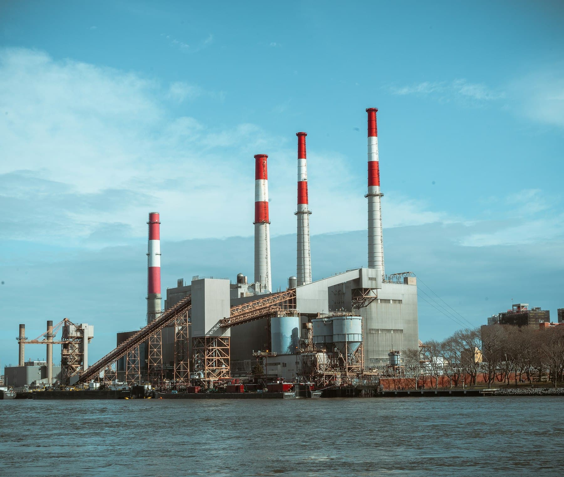 Grey and red power facility under a blue sky