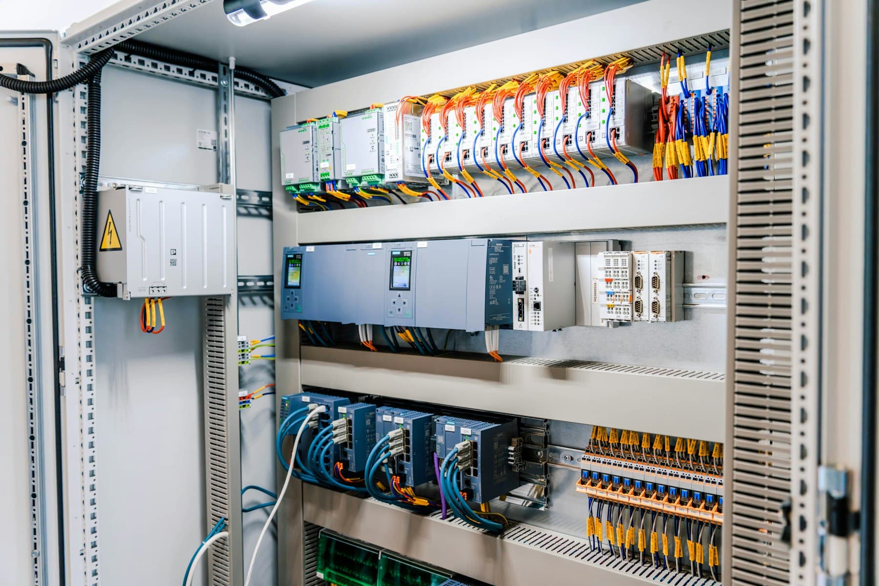 Open industrial control panel with controller modules and terminated wiring