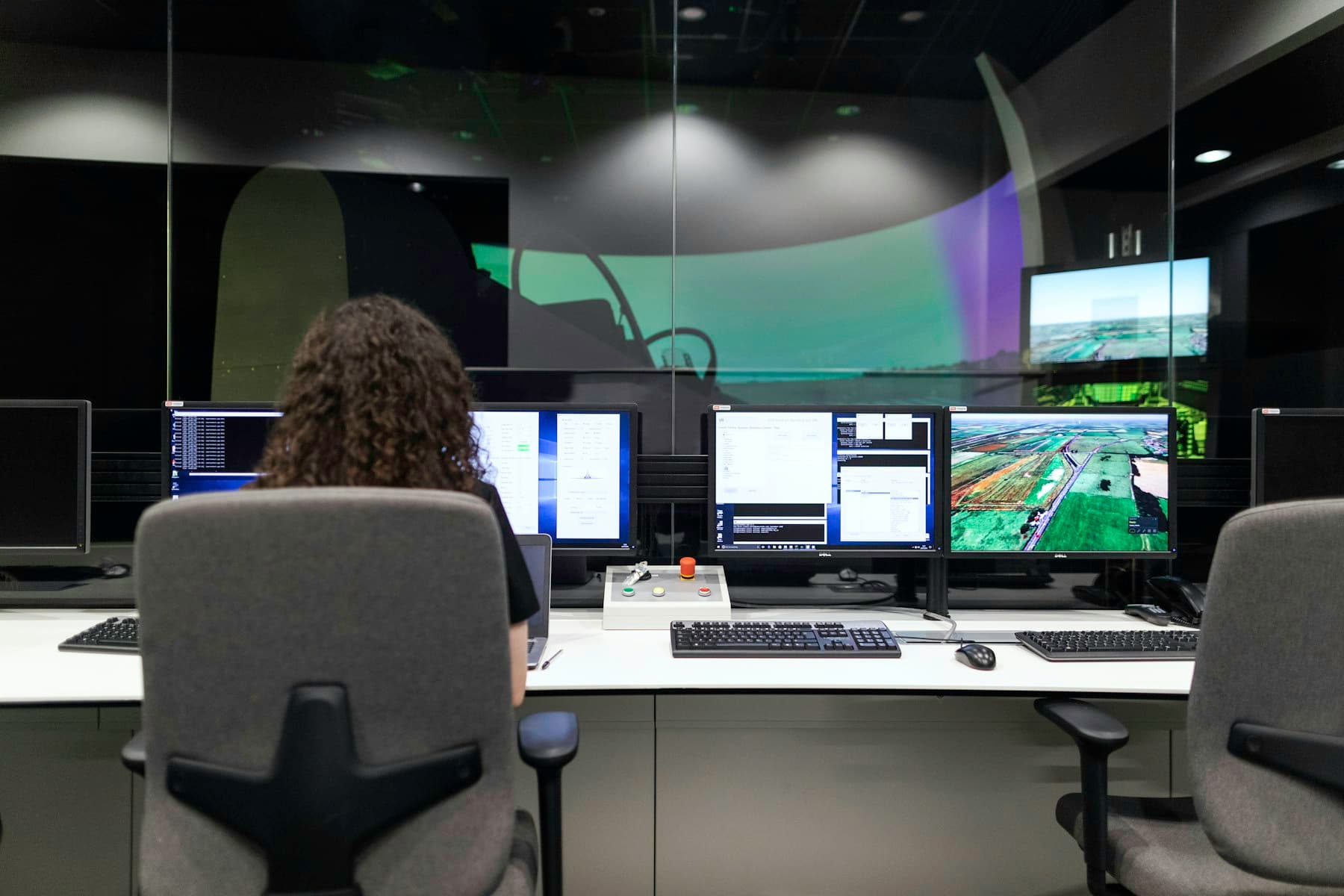 Operator monitoring plant data across multiple screens in a bright control room